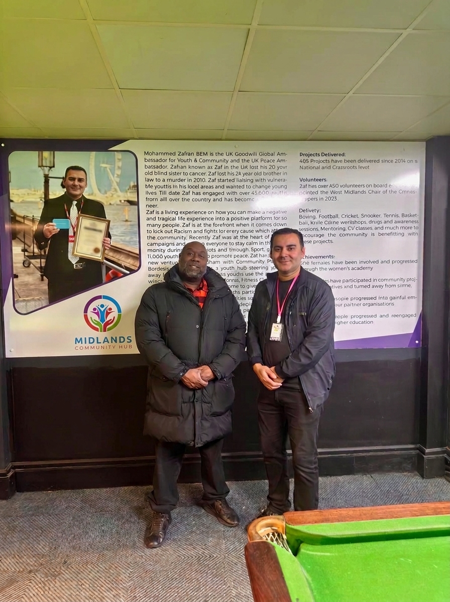 Midlands Community Hub founder with visitor at the Plaza wall